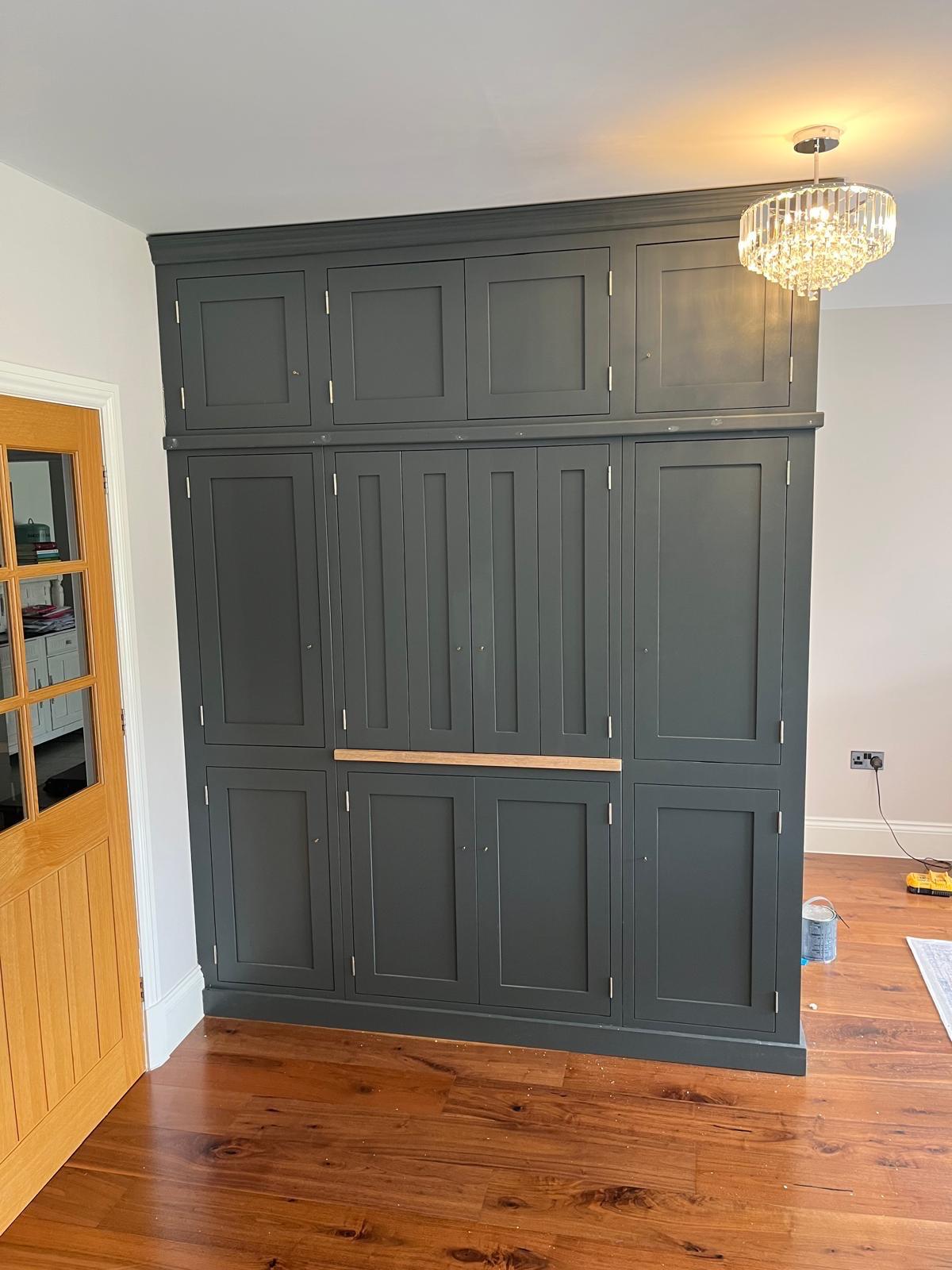 Dark painted fitted drinks cabinet with panelled doors
